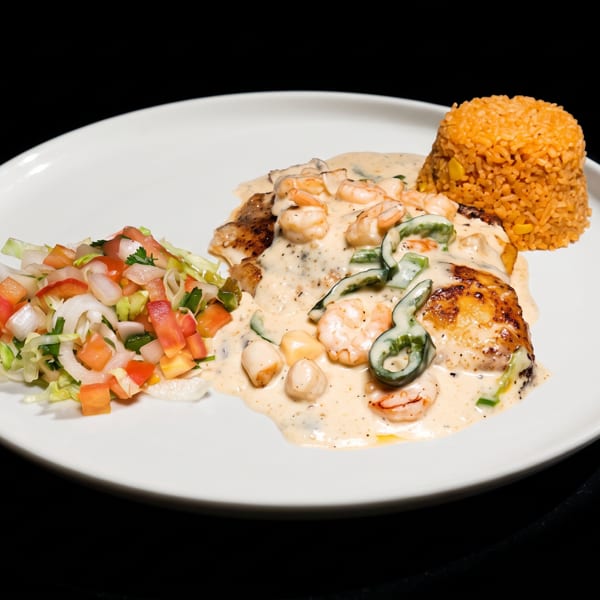 Grilled fish with creamy shrimp, scallop, and pepper sauce, Mexican rice, and fresh pico de gallo.
